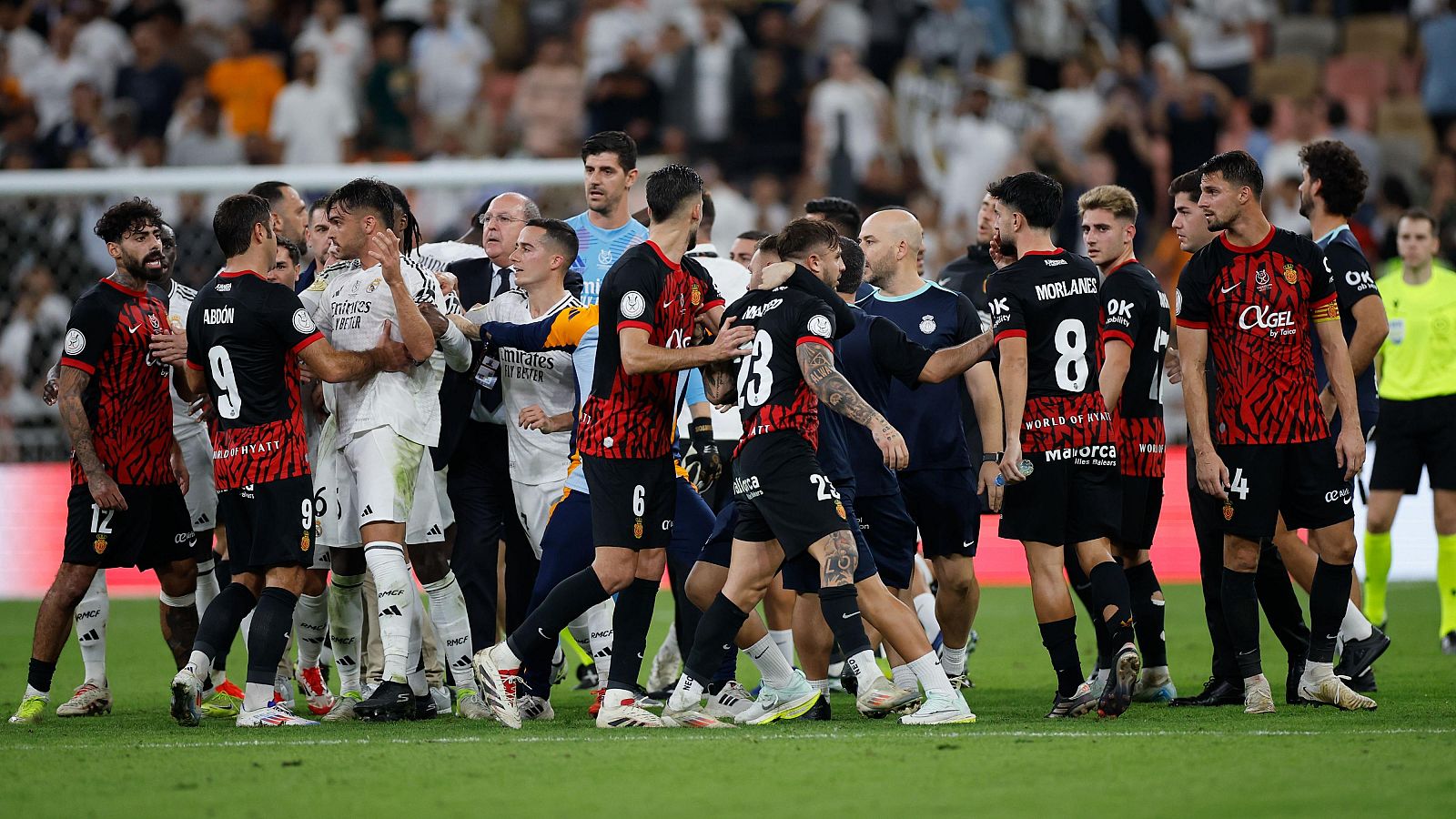 Tangana entre jugadores tras un partido.  Se ven empujones y gestos de recriminación.  Árbitros intentan mediar.