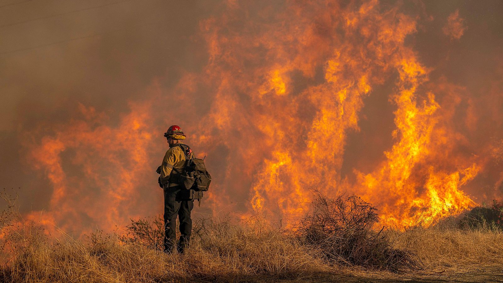 Un bombero combate el incendio en el barrio de Mandeville Canyon en Los Ángeles