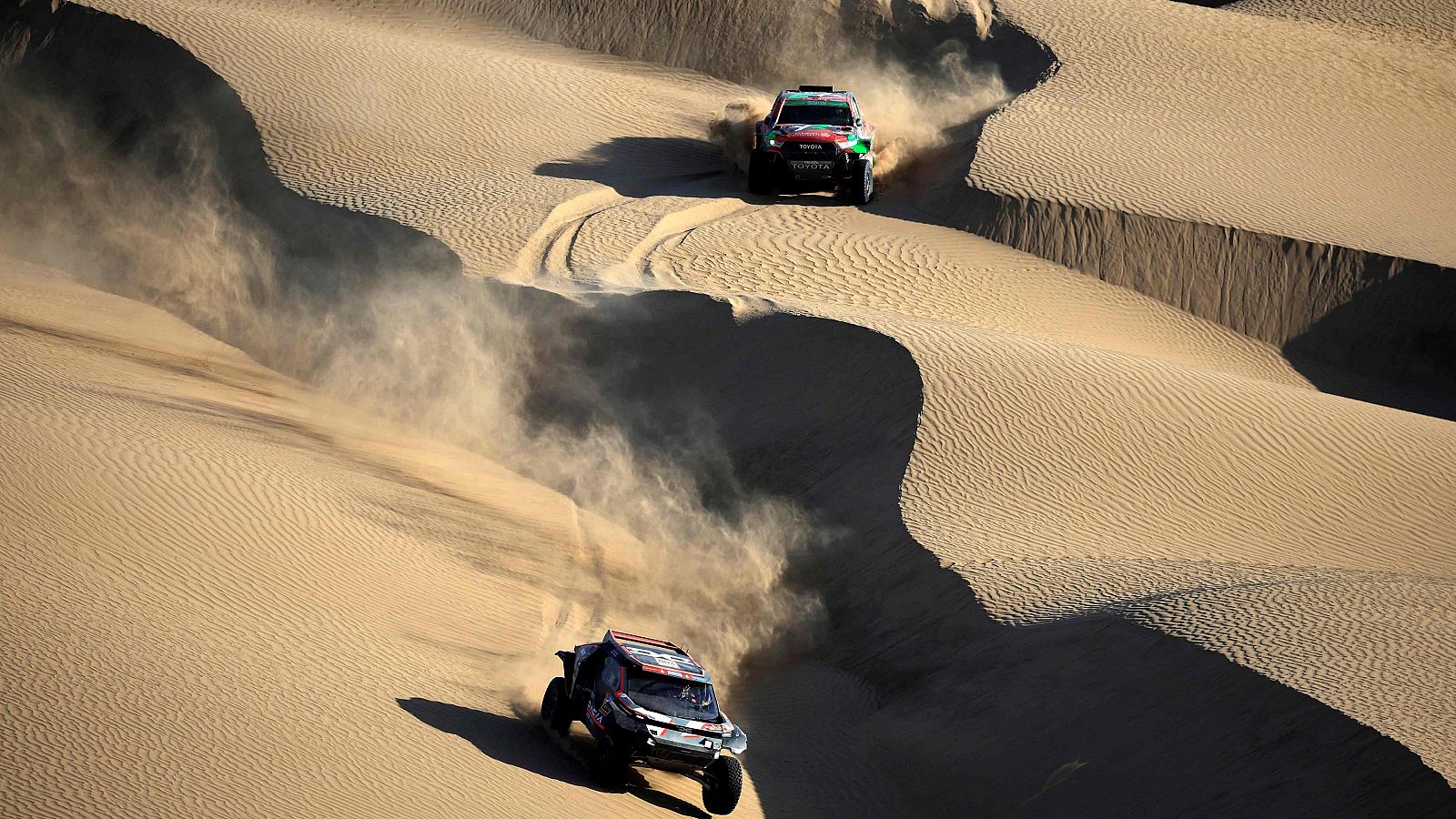 Dos coches entre dunas en una etapa del rally Dakar 2025