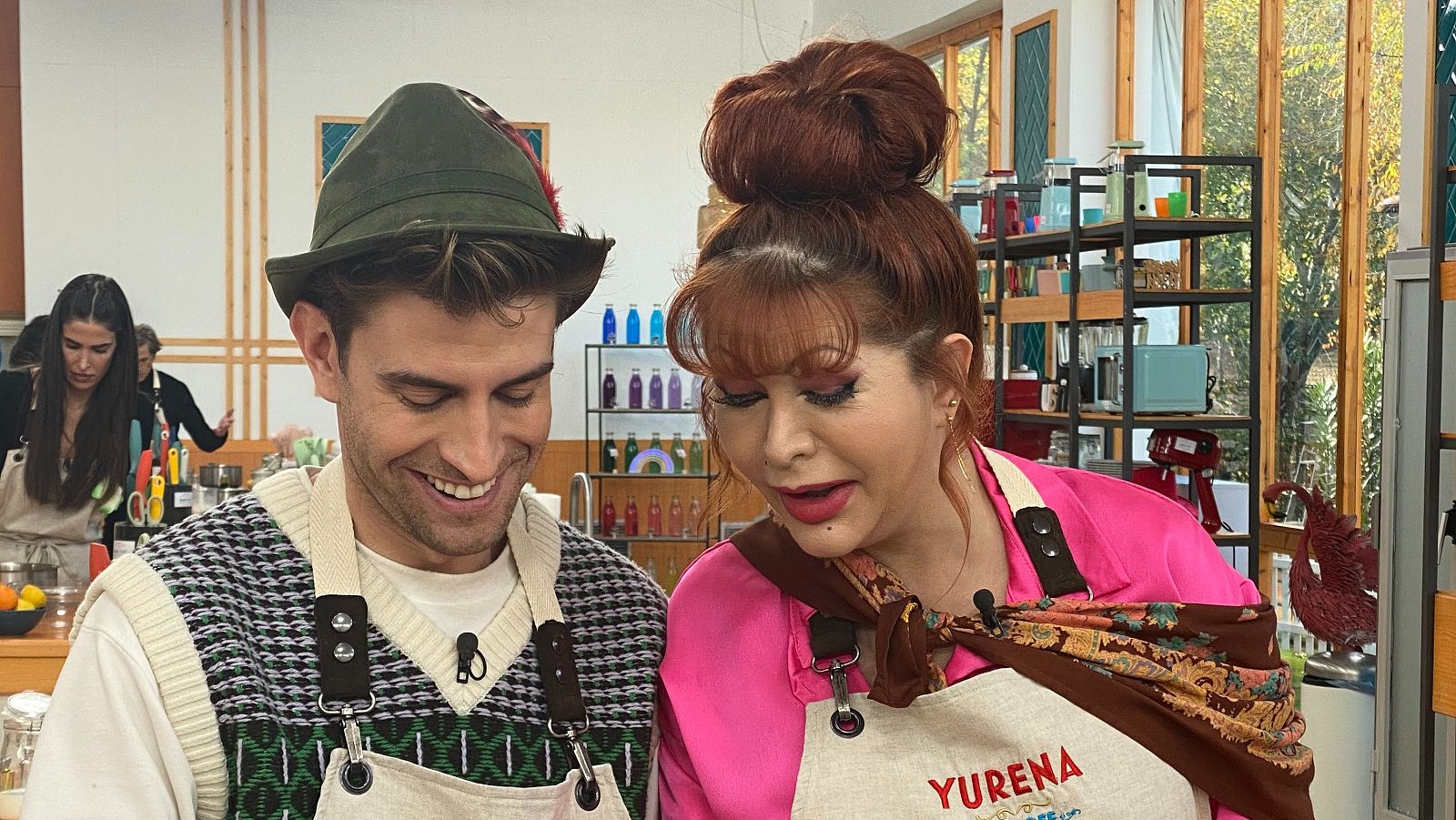 Yurena, con camisa rosa y moño, y Mario Marzo, con sombrero y chaleco, cocinan en 'Bake Off: famosos al horno'.