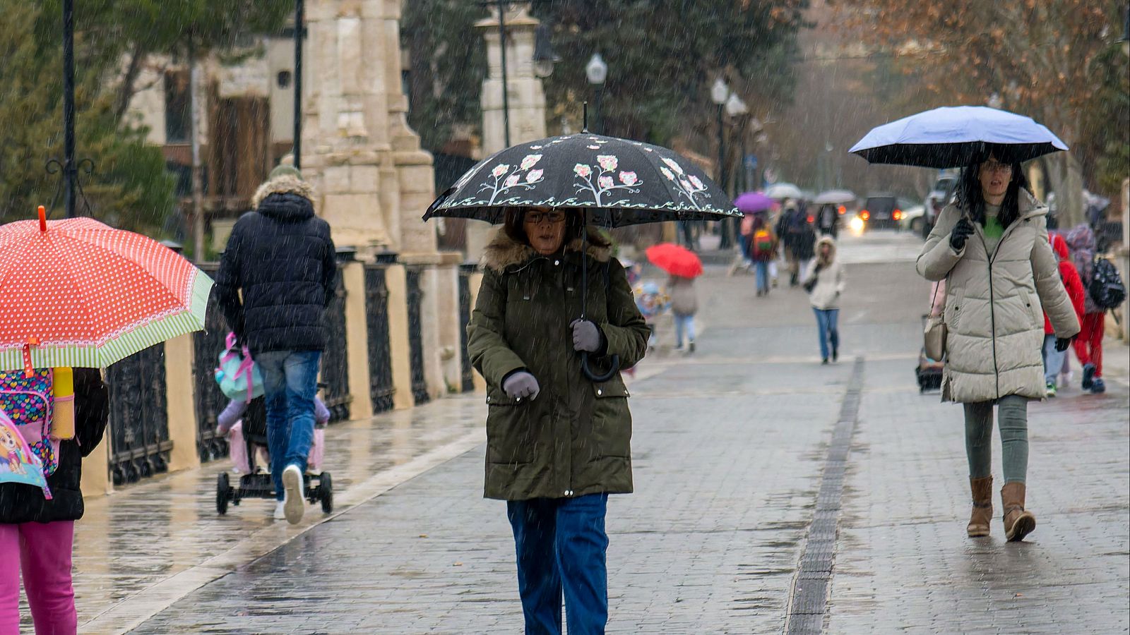 Varias personas caminan bajo la lluvia este lunes en Teruel