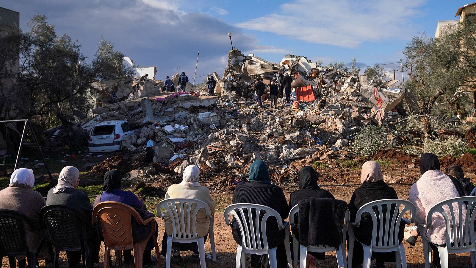 Mujeres palestinas miran los escombros de una casa donde dos militantes palestinos fueron asesinados por Israel en Burqin, cerca de Yenín, Cisjordania