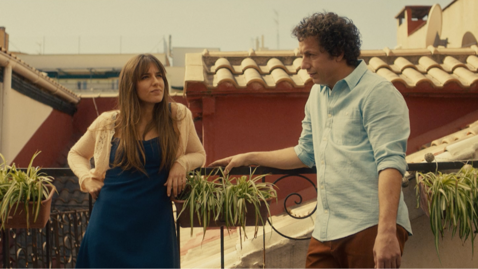 Escena de 'Miocardio': Marina Salas y Vito Sanz, como Ana y Pablo, conversan en una terraza. Ella viste un vestido azul oscuro y rebeca beige; él, camisa azul claro y pantalones marrones.