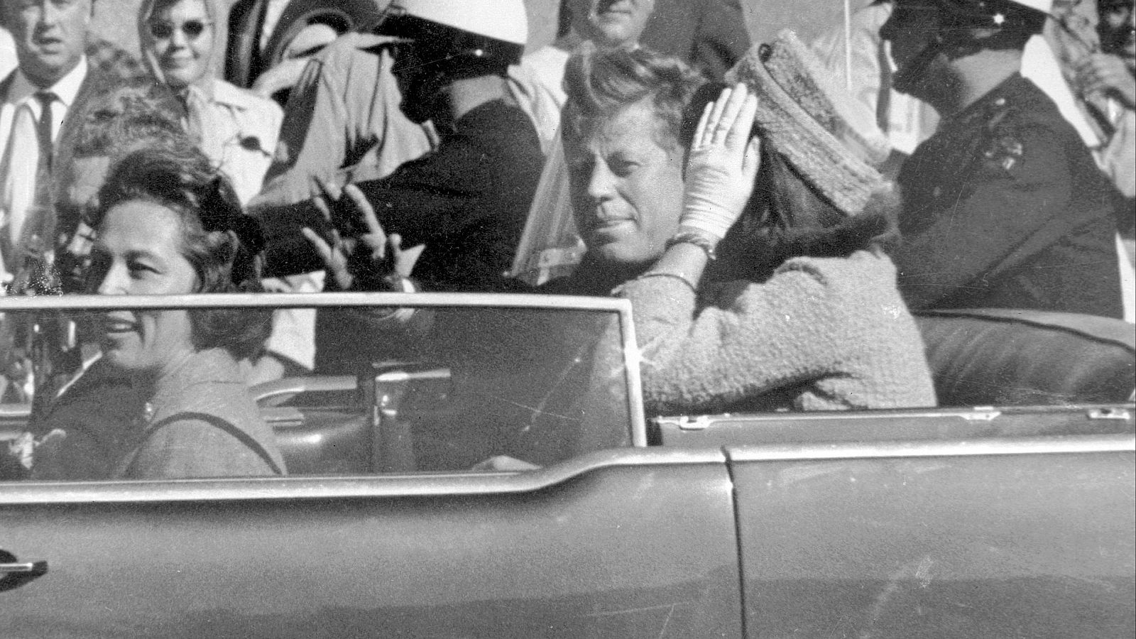 El expresidente estadounidense John F. Kennedy saluda desde su coche en Dallas