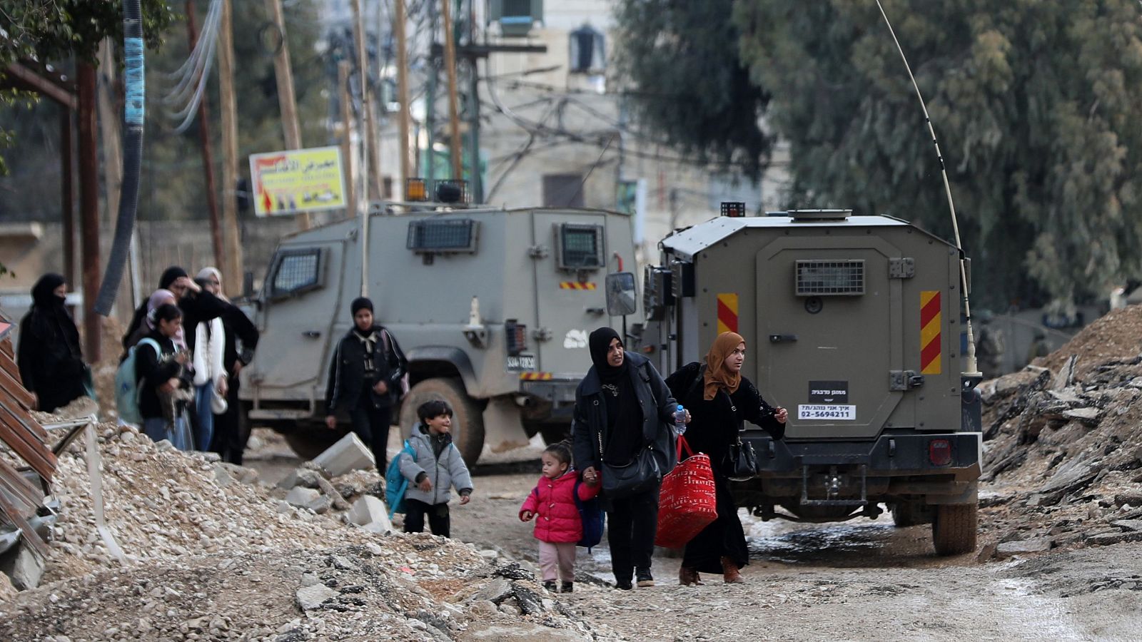 Palestinos cargan con sus pertenencias tras ser expulsados del campo de refugiados de Yenín, Cisjordania