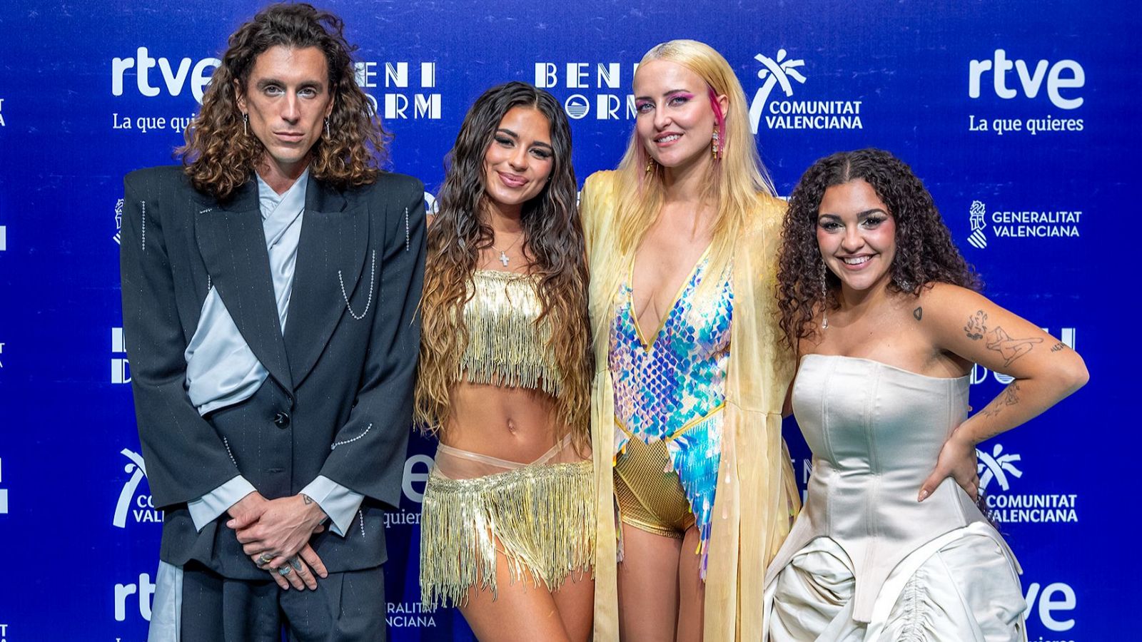 Fotografía de cuatro artistas con vestuario variado, posando frente a un fondo azul con logotipos de RTVE, Comunitat Valenciana y Generalitat Valenciana, y el texto "Benidorm".