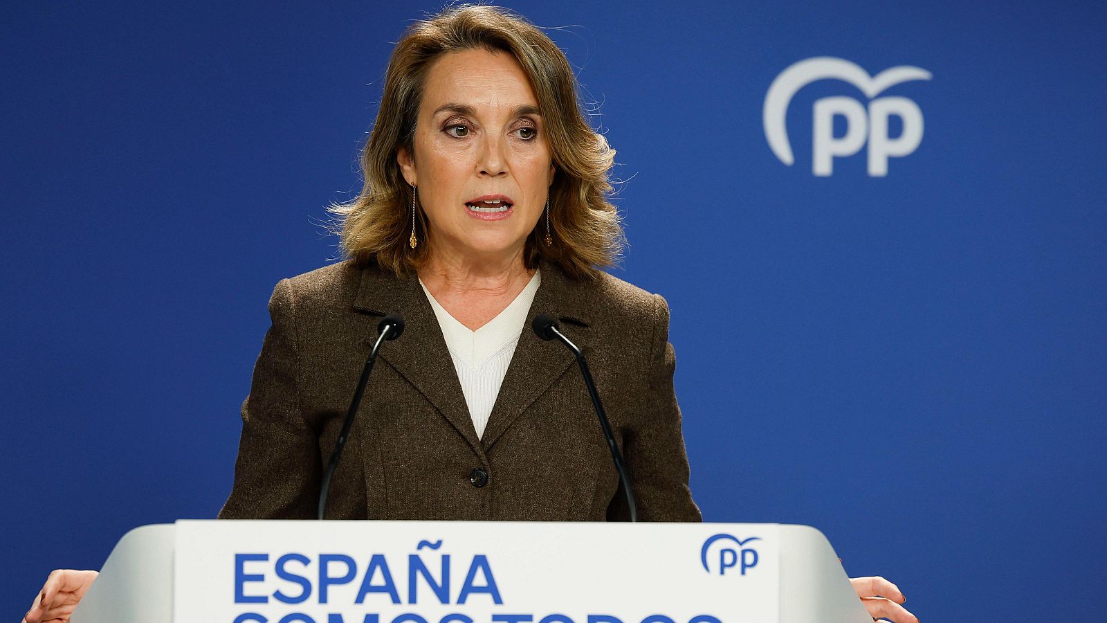 Rueda de prensa de la secretaria general del PP. Habla desde un atril con el logo del partido y la palabra "ESPAÑA", sobre un fondo azul.