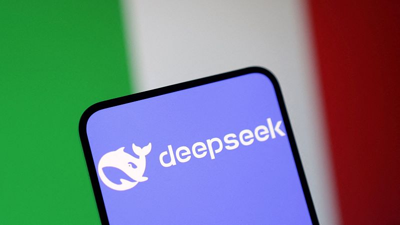 Pantalla de smartphone mostrando el logo de DeepSeek (ballena blanca estilizada) sobre fondo borroso de la bandera italiana.