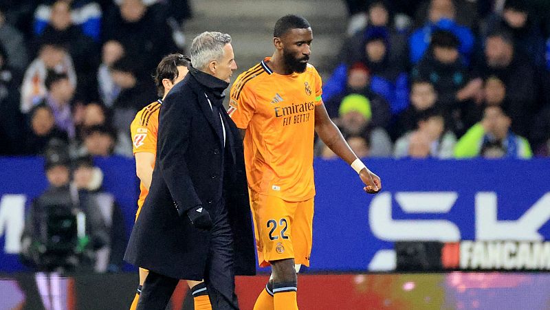 Rüdiger, con el dorsal 22, y Ancelotti, en un campo de juego, con el público borroso.  El jugador del Real Madrid parece desanimado.