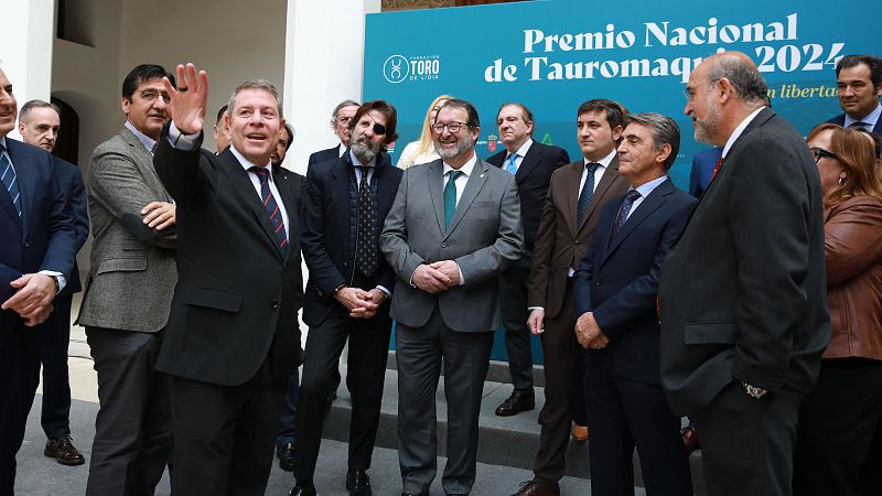 Grupo de hombres en traje en acto oficial de entrega de premio de tauromaquia. Cartel con logo 'Toro de Lidia' y texto 'Premio Nacional de Tauromaquia 2024'.
