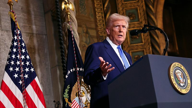 Imagen de archivo: Donald Trump pronunciando un discurso tras un atril con el sello presidencial, flanqueado por banderas estadounidenses.