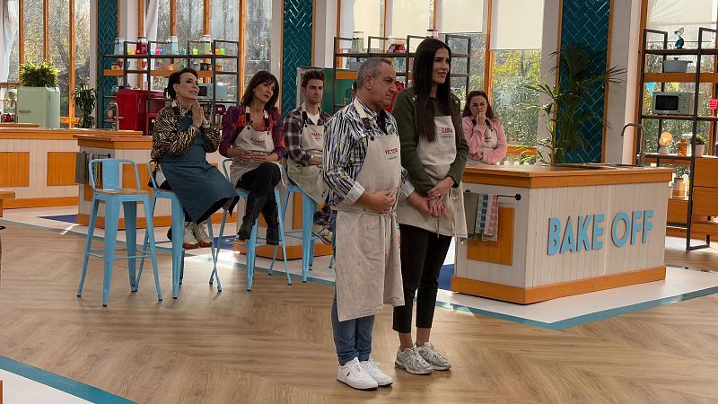 Escena de 'Bake Off: famosos al horno' con Víctor Sandoval y Lidia Torrent, en delantales, aguardando la valoración del jurado en un estudio de cocina.