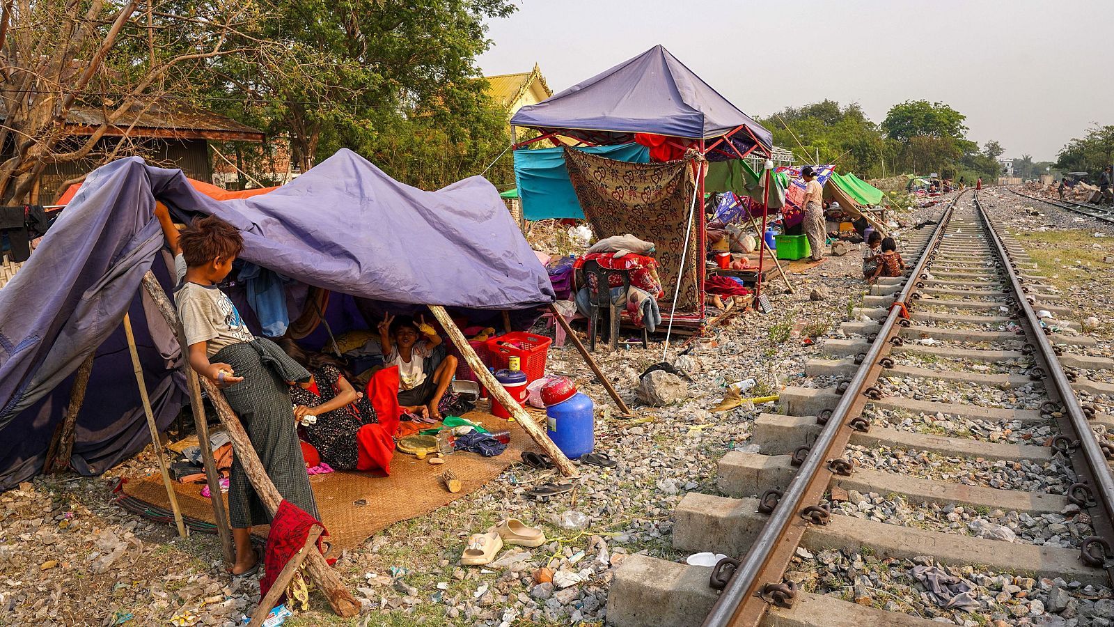 Varias personas se refugian en un campamento improvisado cerca de una vía tras el fuerte terremoto en el municipio de Amarapura, Myanmar, el 4 de abril de 2025.