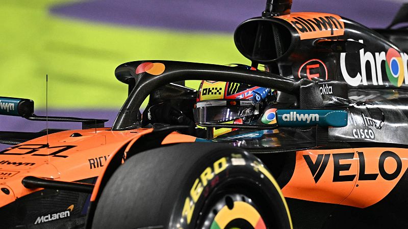 Piloto de McLaren en su monoplaza naranja y negro #81 tras ganar una carrera de F1.  Se ven logos de patrocinadores como Pirelli y McLaren en el coche.