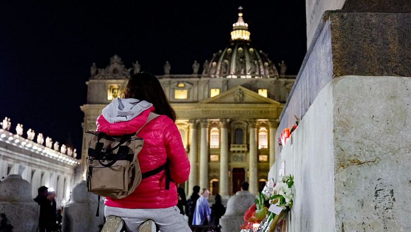 Un fiel reza en la Plaza de San Pedro mientras la gente se reúne tras la muerte del Papa Francisco