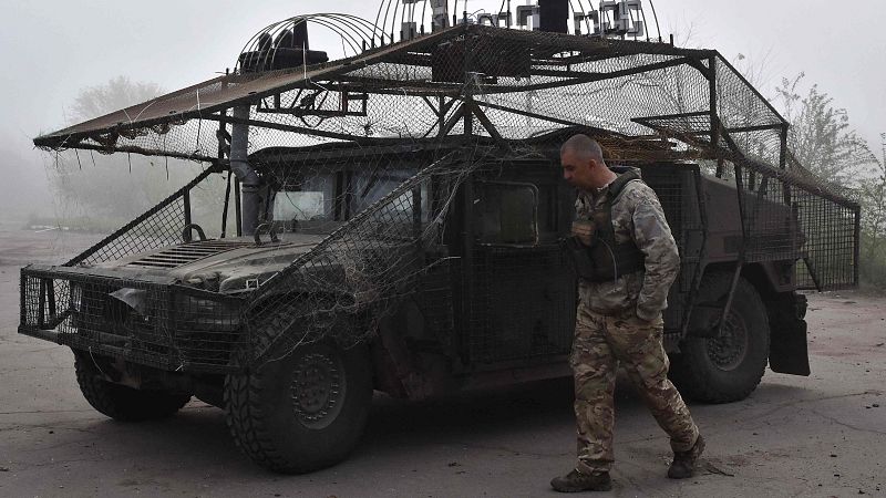 Un militar ucraniano pasa junto a un vehículo militar en un lugar no revelado del frente en la región de Zaporiyia