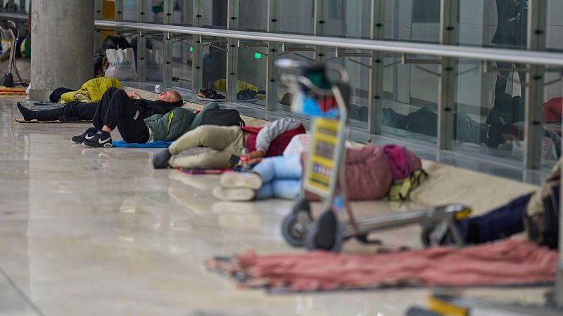 Varias personas duermen en el suelo de la Terminal 4 del aeropuerto Adolfo Suárez-Madrid Barajas