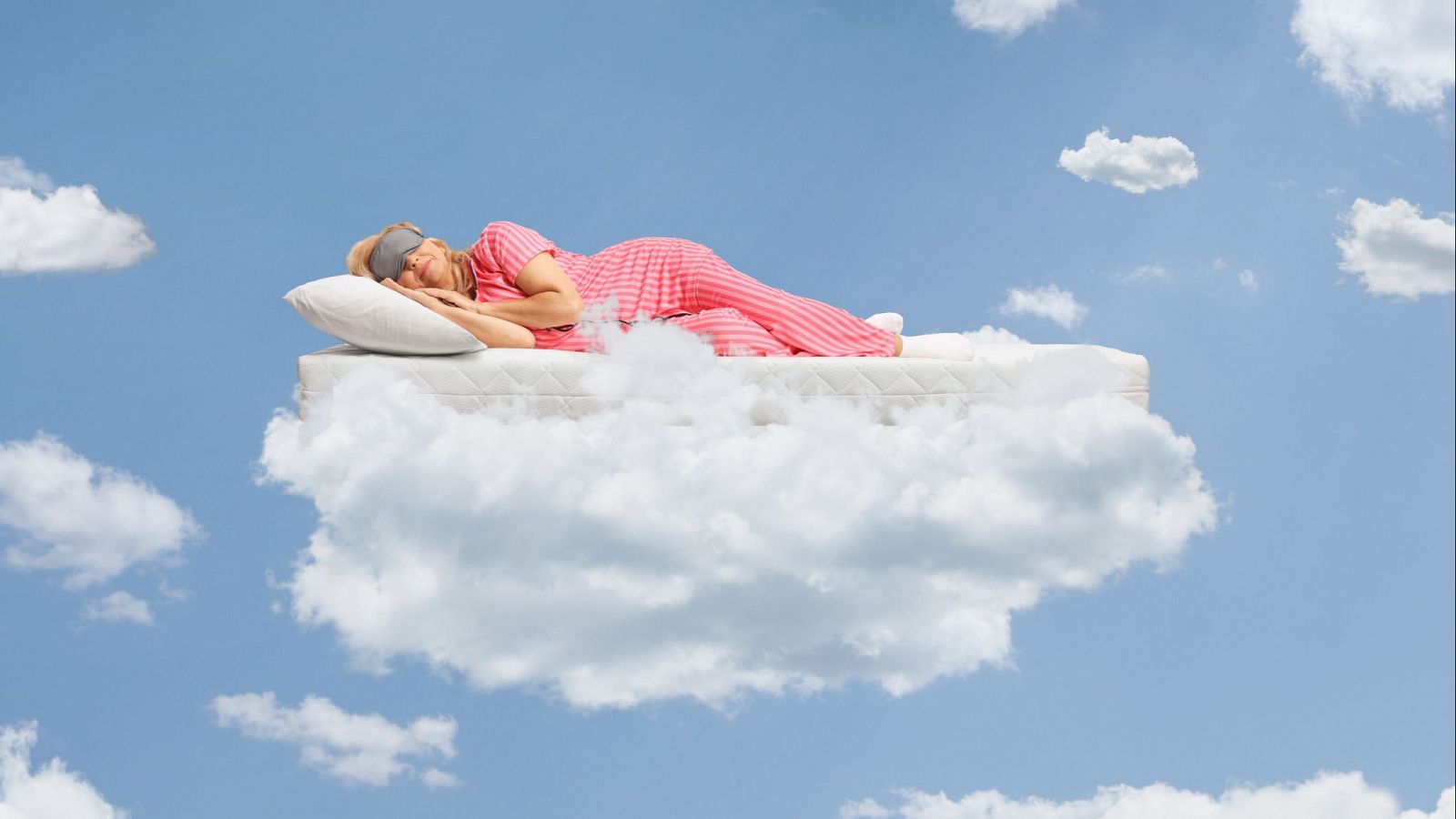 Mujer dormida en colchón flotante sobre nubes, usando antifaz y pijama rosa. Escena pacífica que sugiere un sueño.