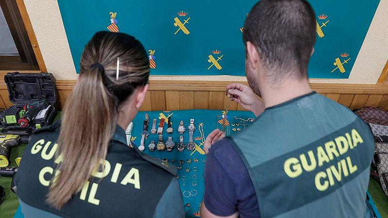 Dos agentes de la Guardia Civil exponen joyas y relojes recuperados en 2023.