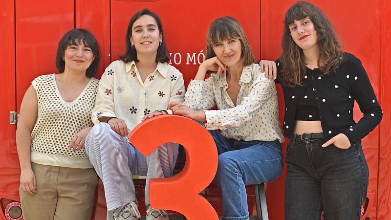 Cuatro mujeres posan ante un fondo rojo con un gran '3' naranja; visten ropa casual y se aprecia parte de un texto en el fondo.