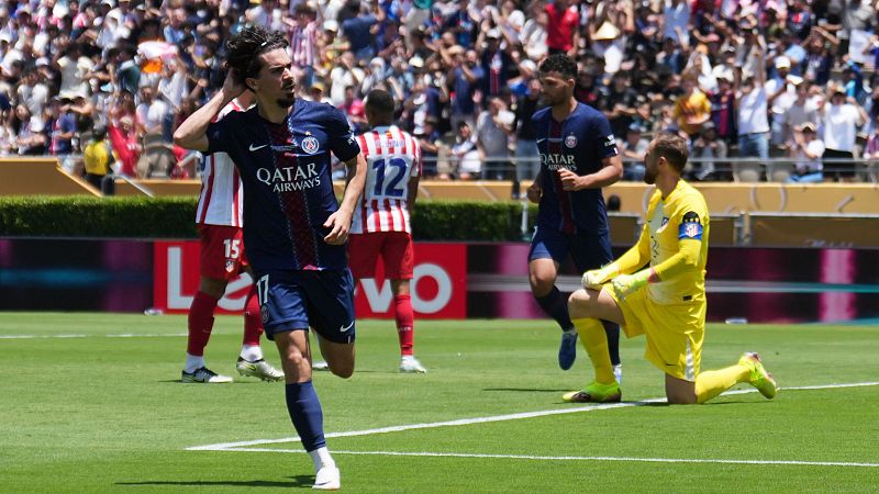 Celebración de gol de un jugador del PSG con el dorsal 17, camiseta azul oscuro y gesto hacia la oreja.  Otros jugadores y el portero también se ven en la imagen.