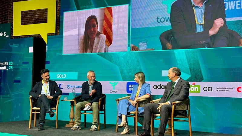Evento de innovación: cuatro personas discuten en un escenario con pantalla mostrando participantes remotos.  Se ven logos de patrocinadores.