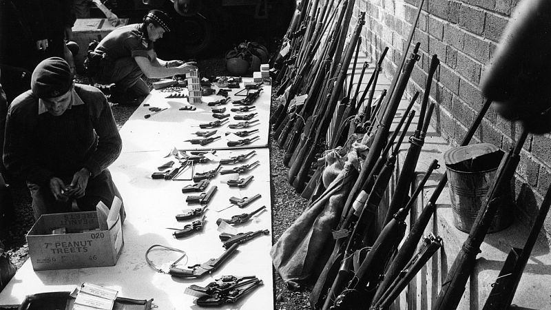Soldados británicos revisan un arsenal incautado al IRA en Belfast