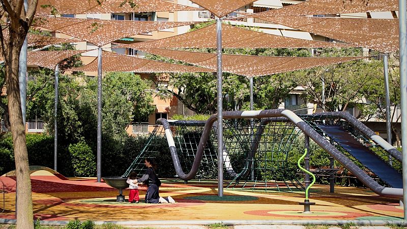 Un parc infantil amb ombres instal·lades