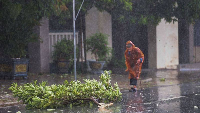 Una mujer caminando por la calle mientras se acerca el tifón