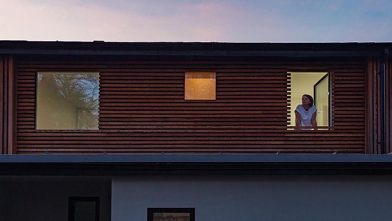 Una mujer en la ventana de su hogar