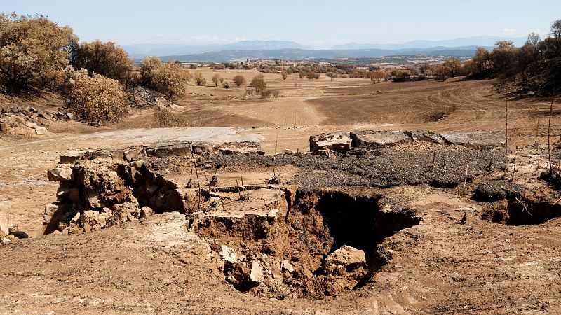 Derrumbe de pared de piedra seca tras el paso del agua. Gran agujero central.  Terreno seco y polvoriento.