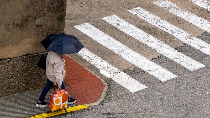 Una mujer con paraguas caminando por la calle en Bocairent, Comunidad Valenciana