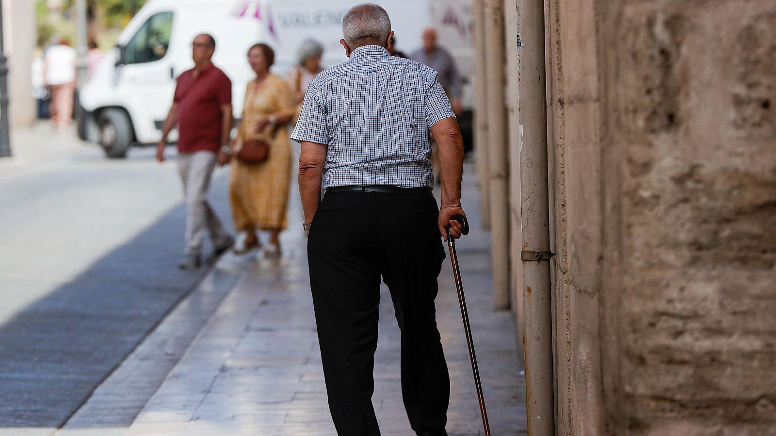 Una persona mayor pasea por el centro de Valencia en una imagen captada el pasado mes de junio
