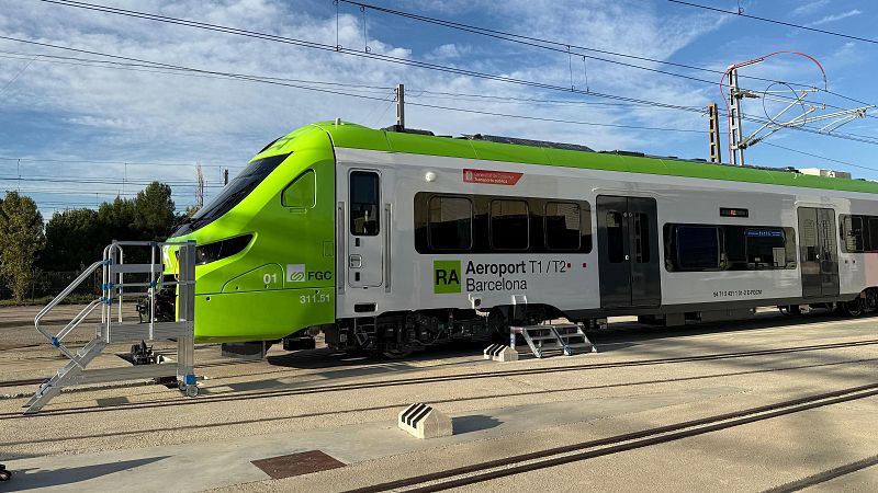 Un tren verde y blanco de la línea R-Aeroport, con el logotipo de FGC, se dirige a las terminales T1 y T2 del aeropuerto de Barcelona. El lateral del tren indica "Aeroport T1/T2 Barcelona".