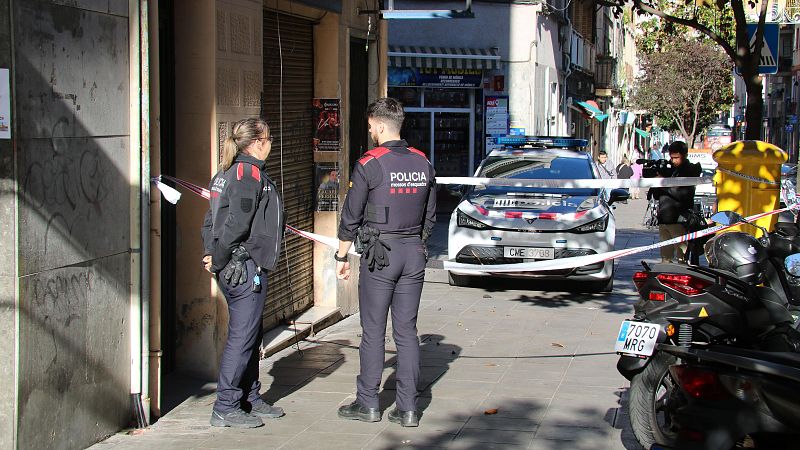 Dos mossos a la porta de l'edifici on vivia la víctima | ACN