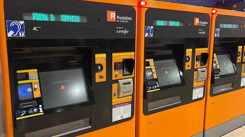 Varias máquinas expendedoras de billetes, con los colores naranja y negro, muestran mensajes de error en sus pantallas. Se aprecian los logotipos de la empresa operadora y las ranuras para tarjetas y billetes.