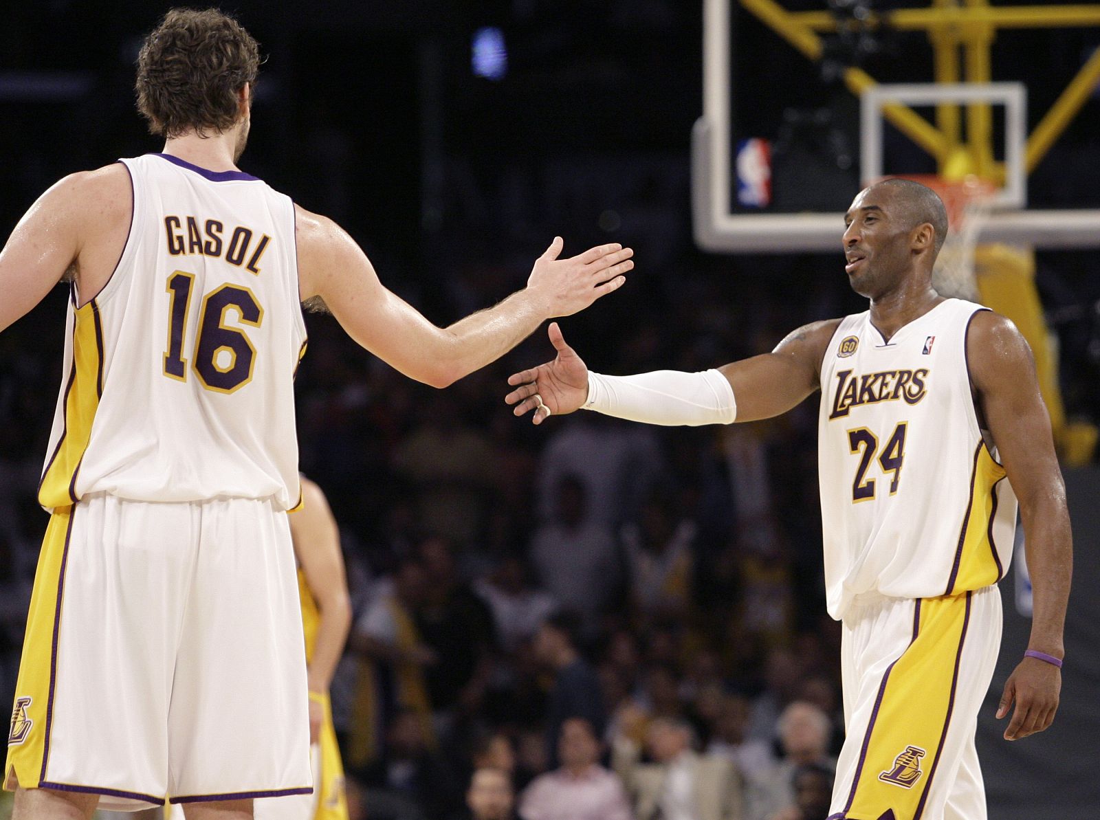 Lakers' Bryant celebrates a Game 1 win over Jazz as he slaps hands with teammate Gasol during their NBA basketball playoff series