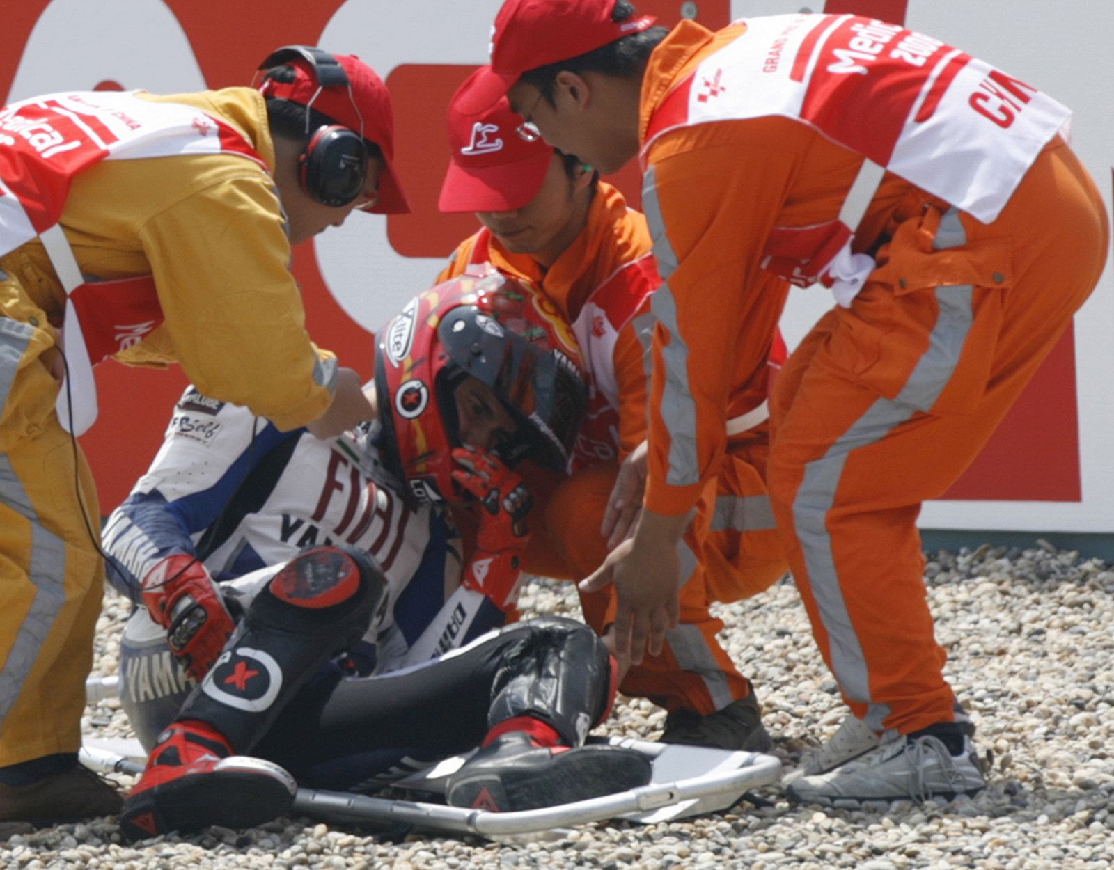 MotoGP rider Lorenzo of Spain is helped onto a stretcher after he crashed during the first day practice session of the China Grand Prix at the Shanghai International Circuit