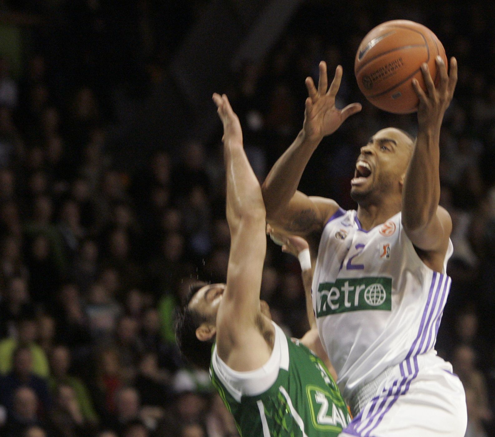 Louis Bullock of Real Madrid goes for the basket as Marko Popovic of Zalgiris tries to block him during their men's Euroleague basketball game in Kaunas