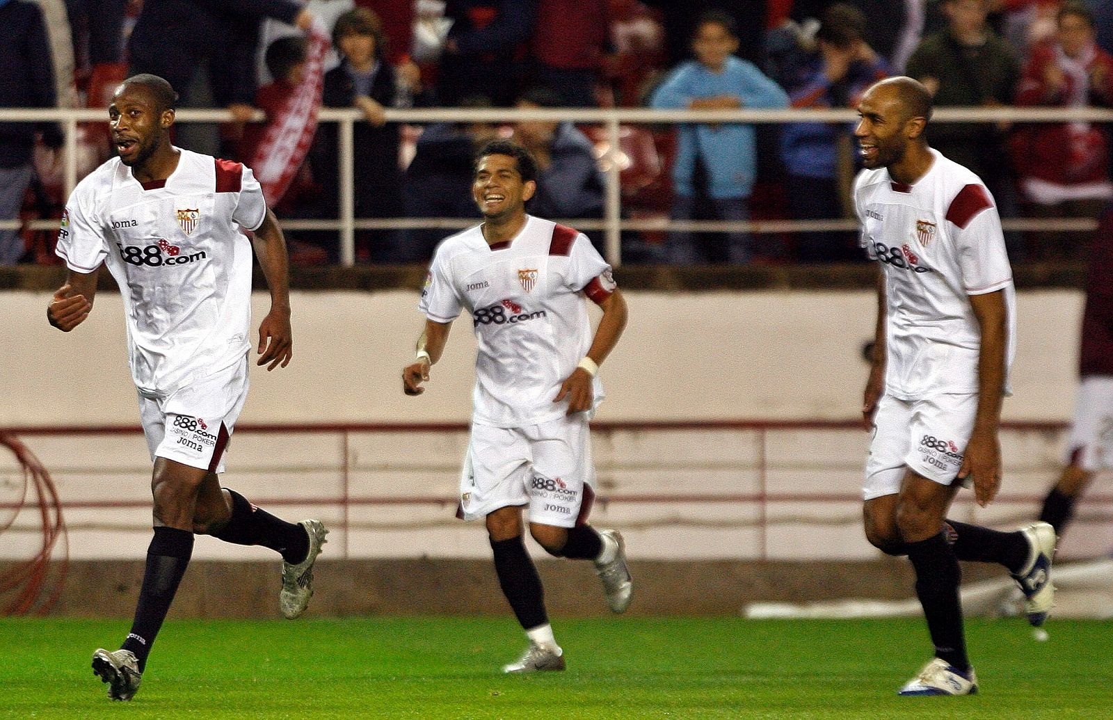 Seydou Keita, Daniel Alves y Frederic Kanouté celebran un gol frente al Zaragoza en partido de Liga.