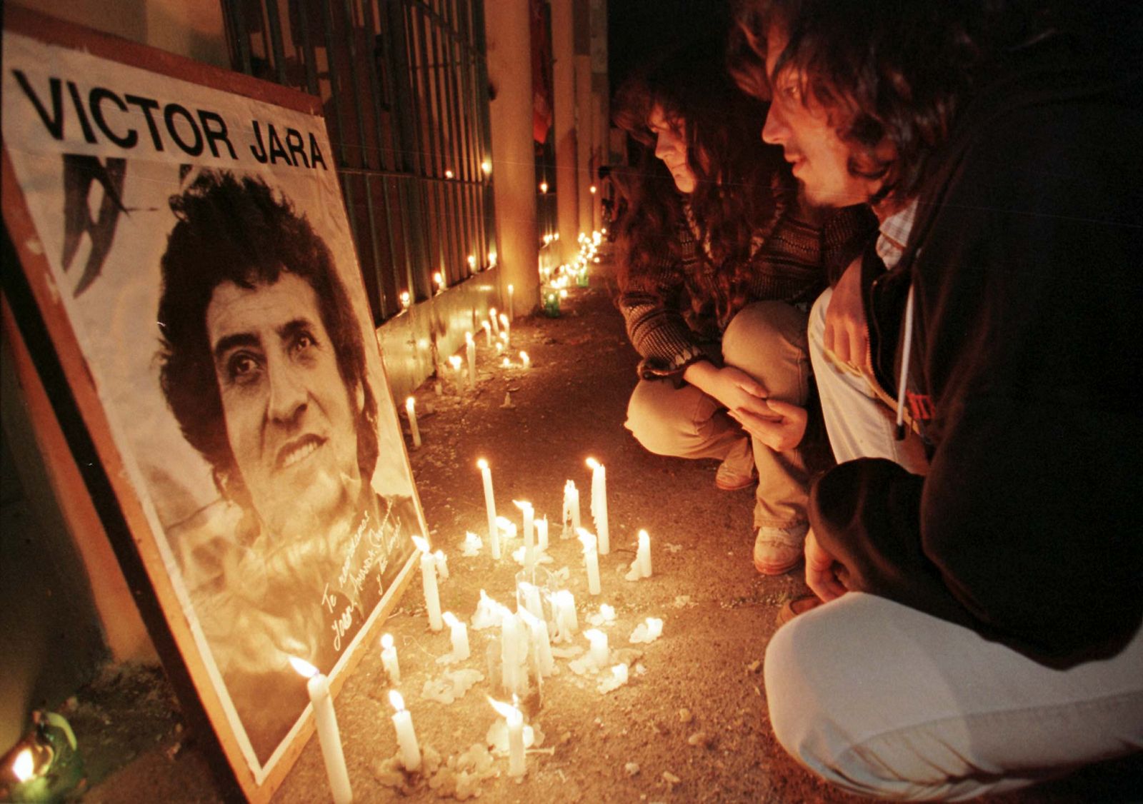 Una pareja rinde homenaje a Victor Jara en las afueras del Estadio Chile de Santiago, donde fue asesinado.