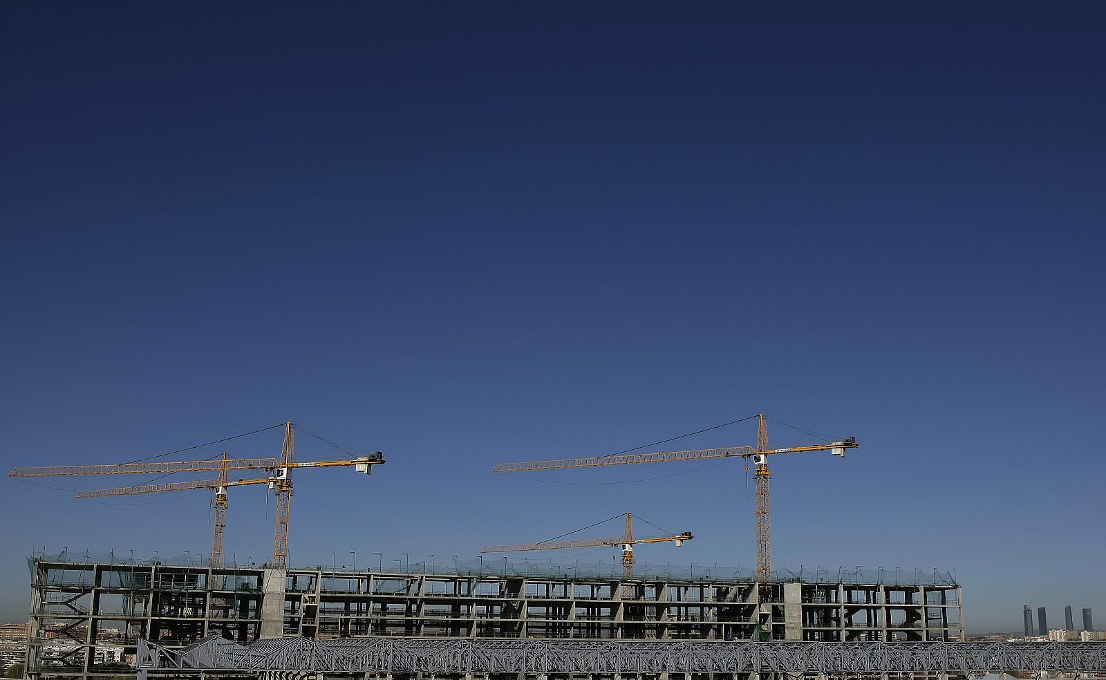 Obras del Centro Olímpico Acuático de Madrid, con las Cuatro Torres al fondo.