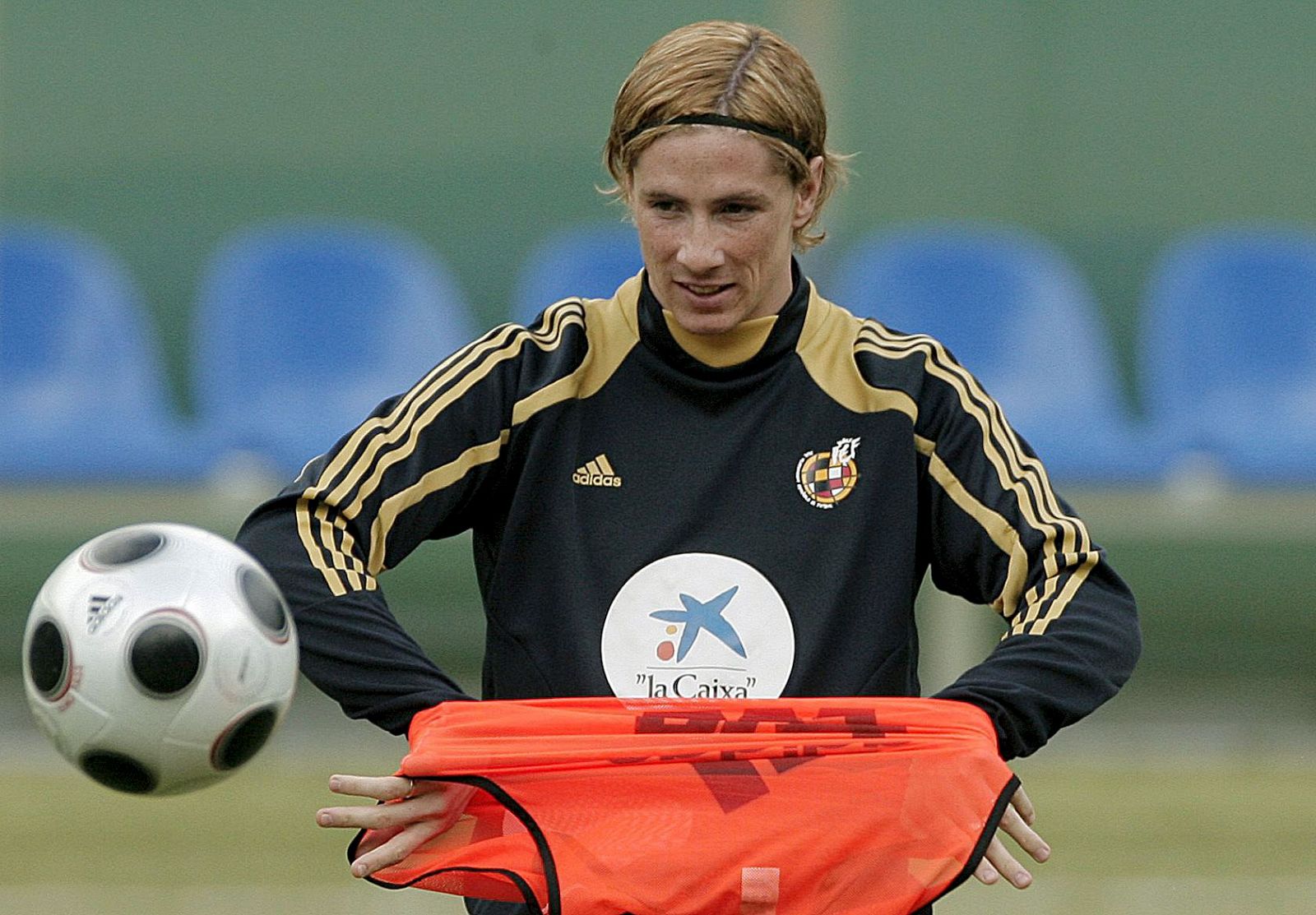 El delantero de España Fernando Torres mira el balón mientras se coloca un peto en un entrenamiento de la selección