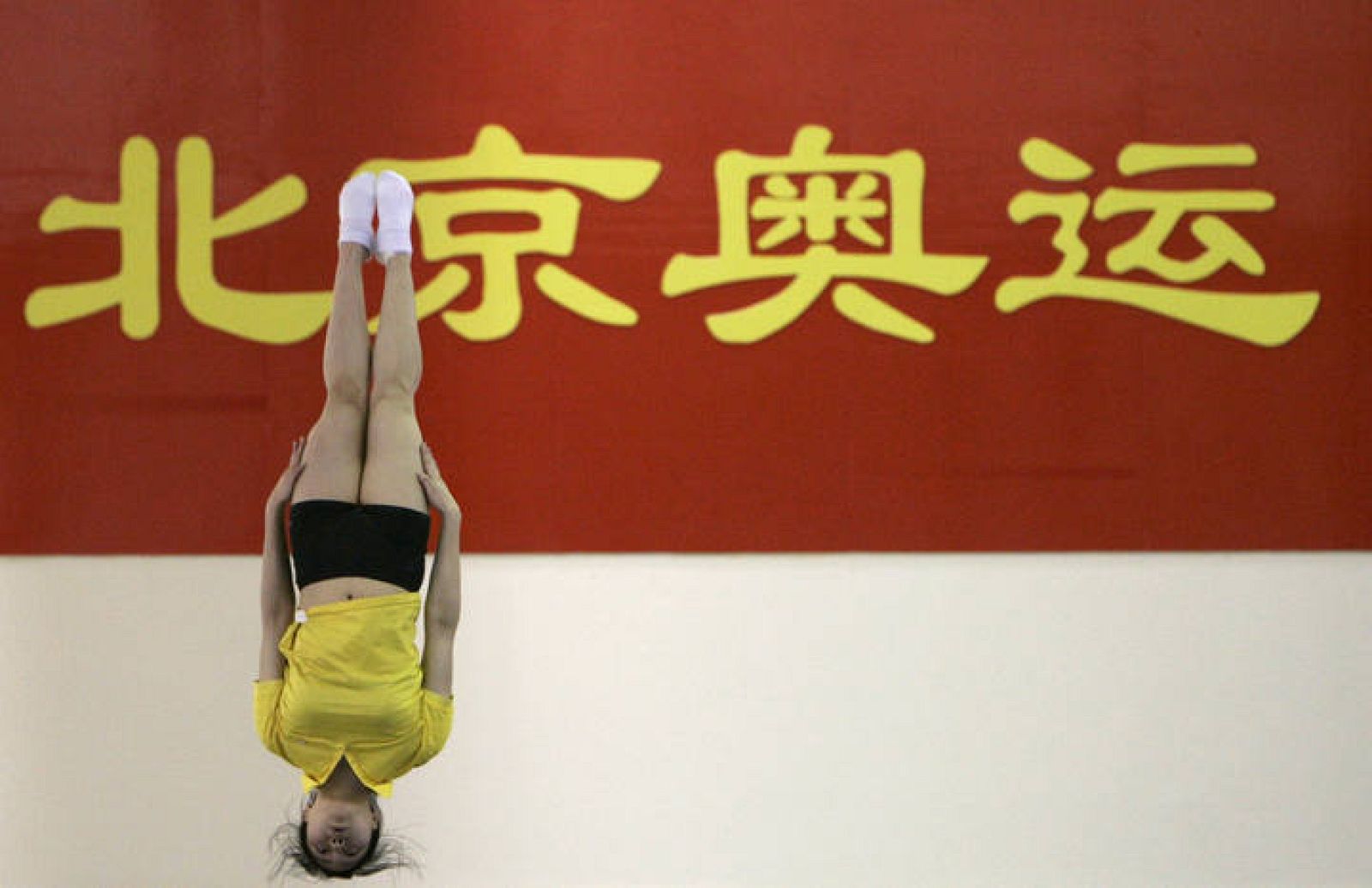 Una atleta China practica un salto desde el trampolín en una sesión de entrenamiento.