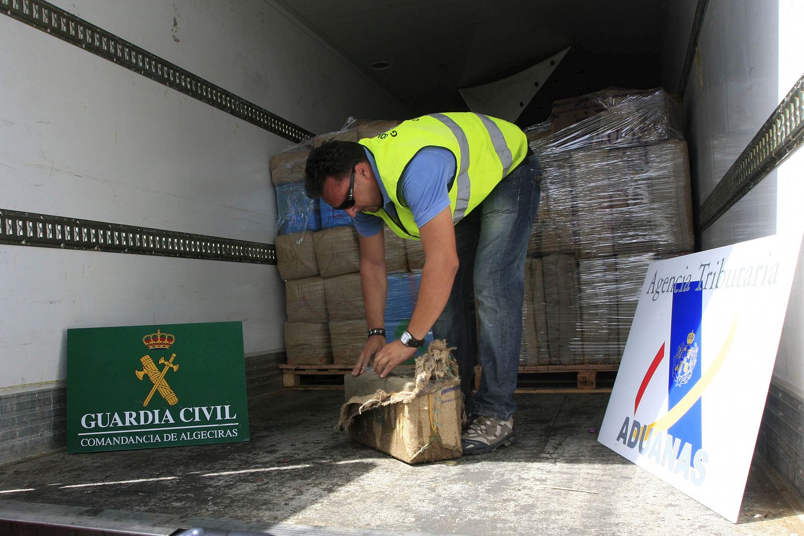 Un agente de la Guardia Civil inspecciona uno de los fardos de droga, 19,4 toneladas de polen y resina de hachís, que han incautado hoy en un semirremolque en el puerto de Algeciras (Cádiz) procedente de Tánger (Marruecos).