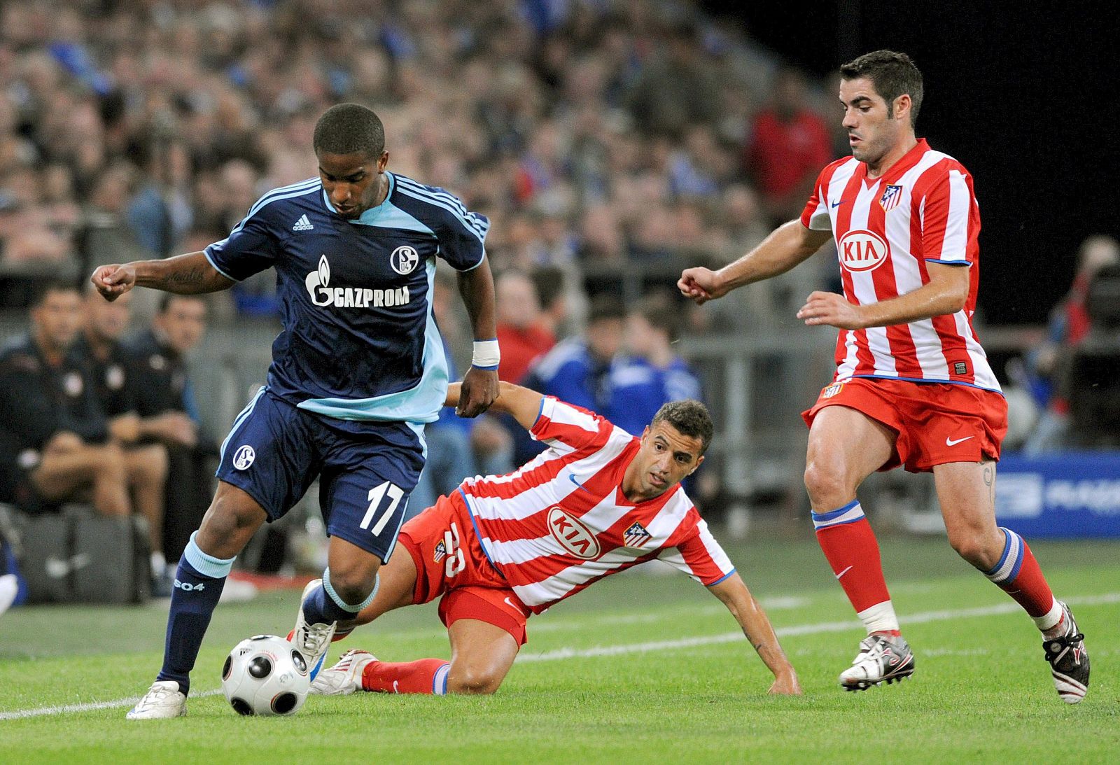 El jugador del Schalke 04 Jefferson Farfan disputa el balón con sus rivales del Atlético de Madrid español Simao y Antonio Lopez.