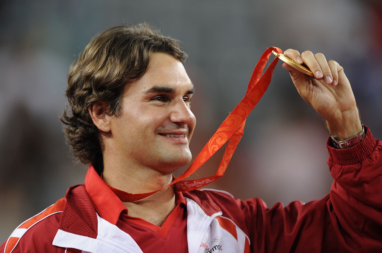 Federer muestra orgulloso su medalla de oro durante la ceremonia de entrega.