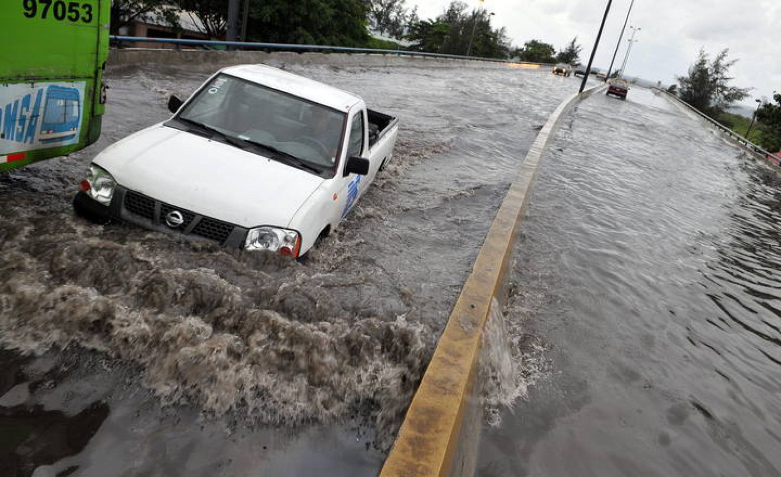 Vehículos circulan por una avenida inundada en Santo Domingo (República Dominicana) el 16 de agosto de 2008, producto de las fuertes lluvias que ha ocasionado a su paso la tormenta tropical 'Fay'. 