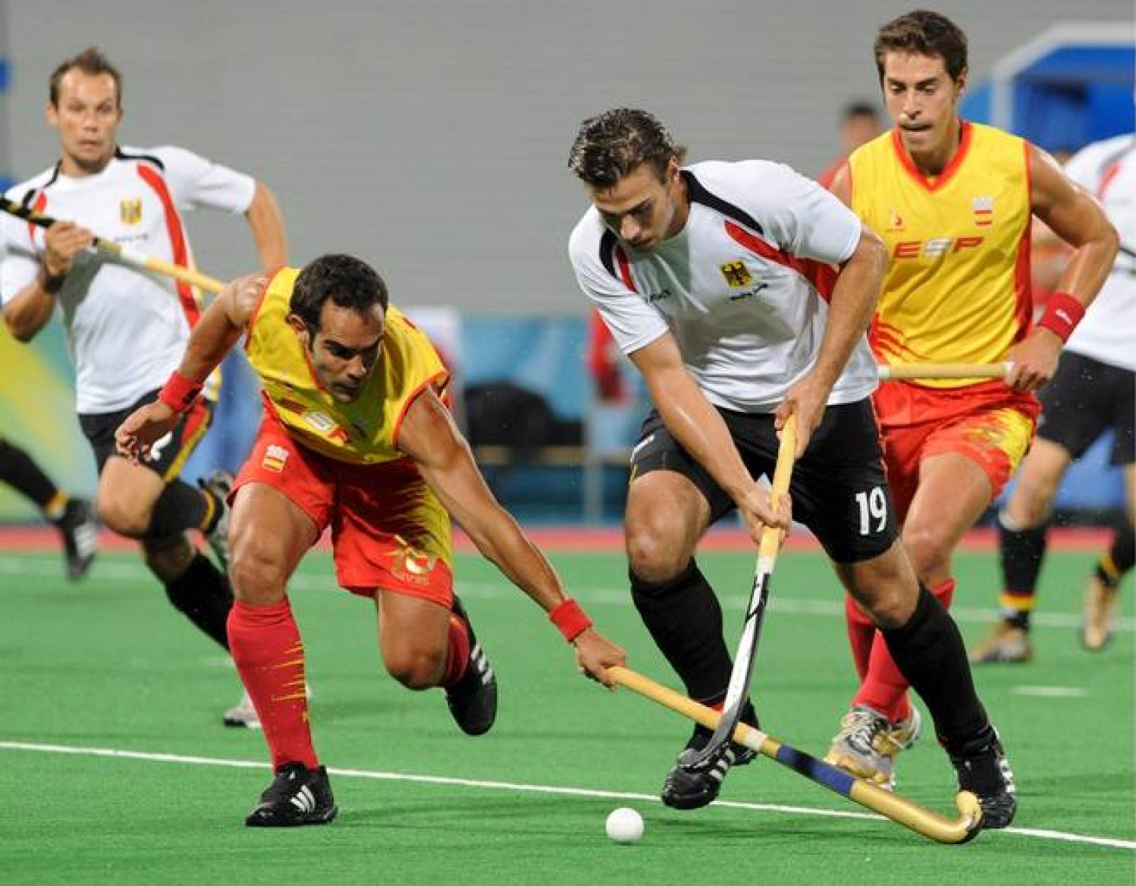 Los jugadores de la selección olímpica española de hockey hierba Xavier Ribas y Alex Fábregas luchan por la pelota ante los alemanes Matthias Witthaus y Christopher Zeller.