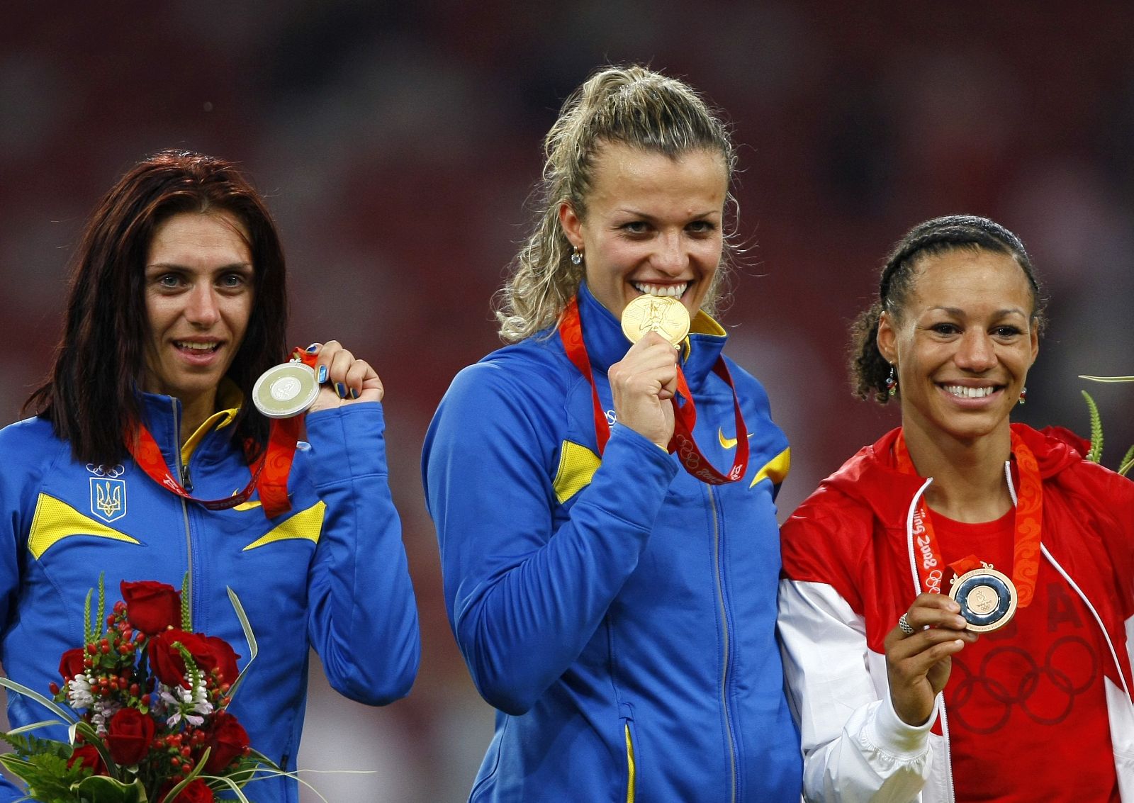 Silver medallist Blonska of Ukraine, gold medallist Dobrynska of Ukraine pose with bronze medallist Fountain of the U.S. after competing in the women's heptathlon in the athletics competition in the National Stadium at the Beijing 2008 Olympic Games